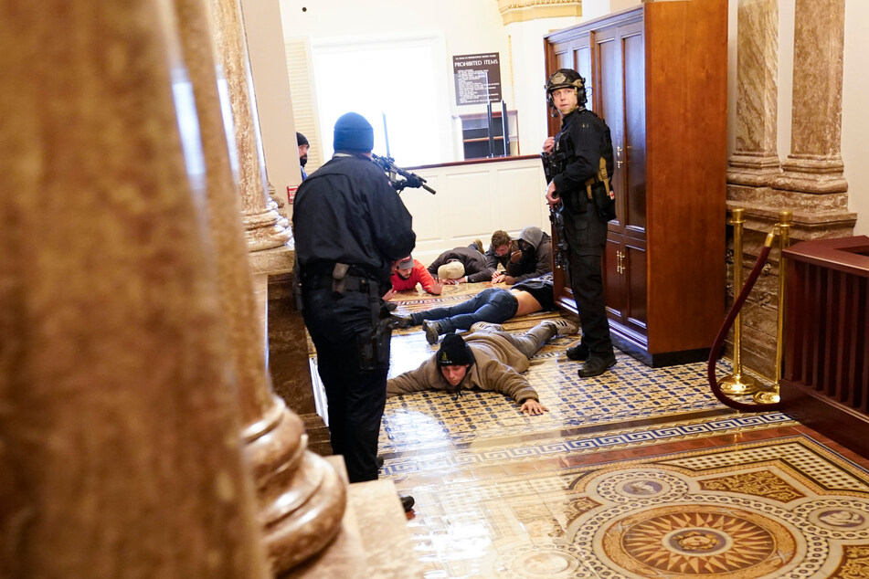 6. Januar 2021: Die US-Kapitol-Polizei hält Demonstranten mit vorgehaltener Waffe fest, nachdem das Gebäude gestürmt worden war.