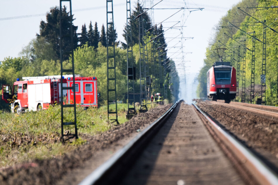 Eine S-Bahn steht auf einem Gleis, daneben Rettungsfahrzeuge. (Archivbild)