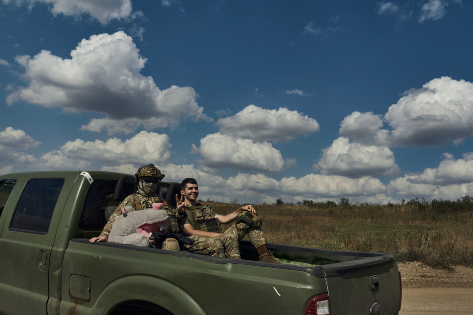 Soldaten der 3. Separatistenbrigade der Ukraine zeigen ein Siegeszeichen, während sie auf einem Pickup in der Nähe von Bachmut fahren.