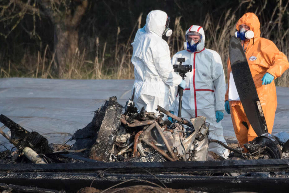 Beamte der Kriminalpolizei und Luftfahrtexperten der Bundesstelle für Flugunfalluntersuchung (BfU) untersuchen das Flugzeugwrack.