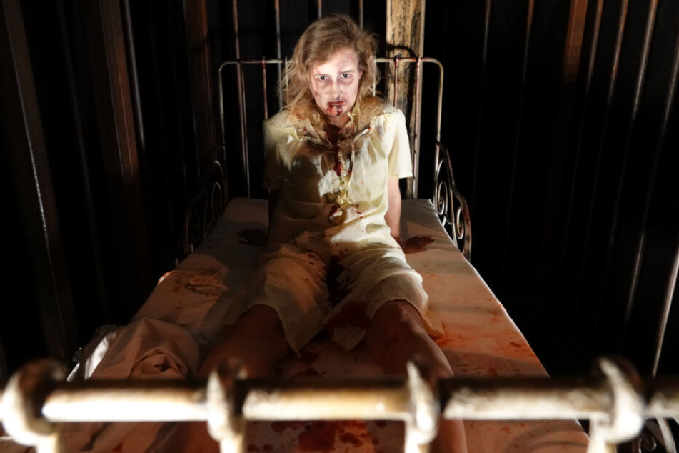 Schauspielerin Janine von Ende liegt mit Kunstblut überströmt auf einem Bett im "Hamburg Dungeon".