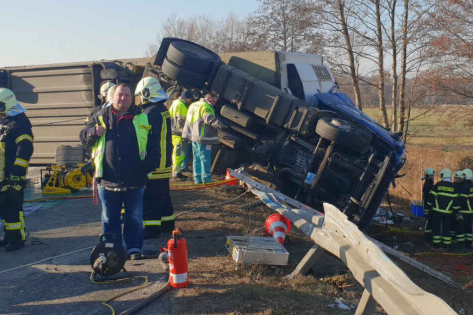 Feuerwehrleute betrachten den Lkw.