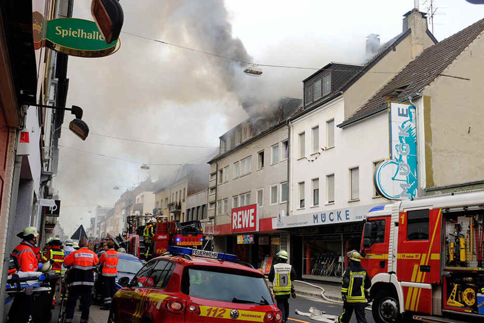 Feuerwehrleute löschen das Feuer in dem Wohnhaus in der Innenstadt von Krefeld.