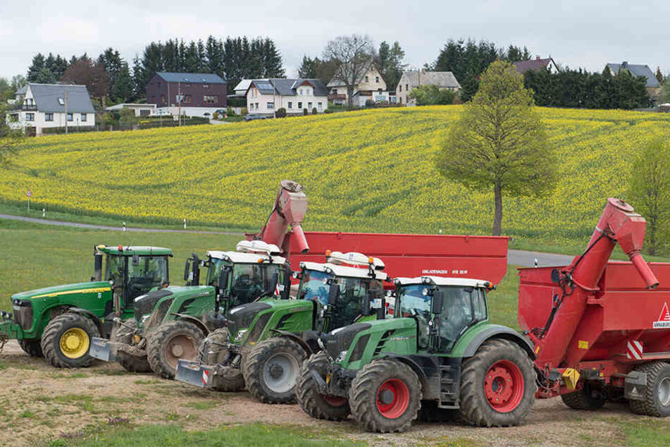 GPS-gesteuerte Traktoren der Ruppendorfer Argrargesellschaft stehen bei Klingenberg vor einem Rapsfeld.
