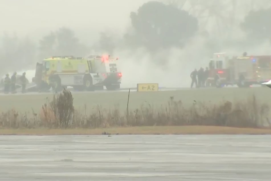 Dieser Screenshot aus einem von WSOC zur Verfügung gestellten Video zeigt Feuerwehrleute, die bei einem Flugzeugabsturz auf einem Regionalflughafen in Statesville im Einsatz sind, bei dem ein Feuer ausbrach.