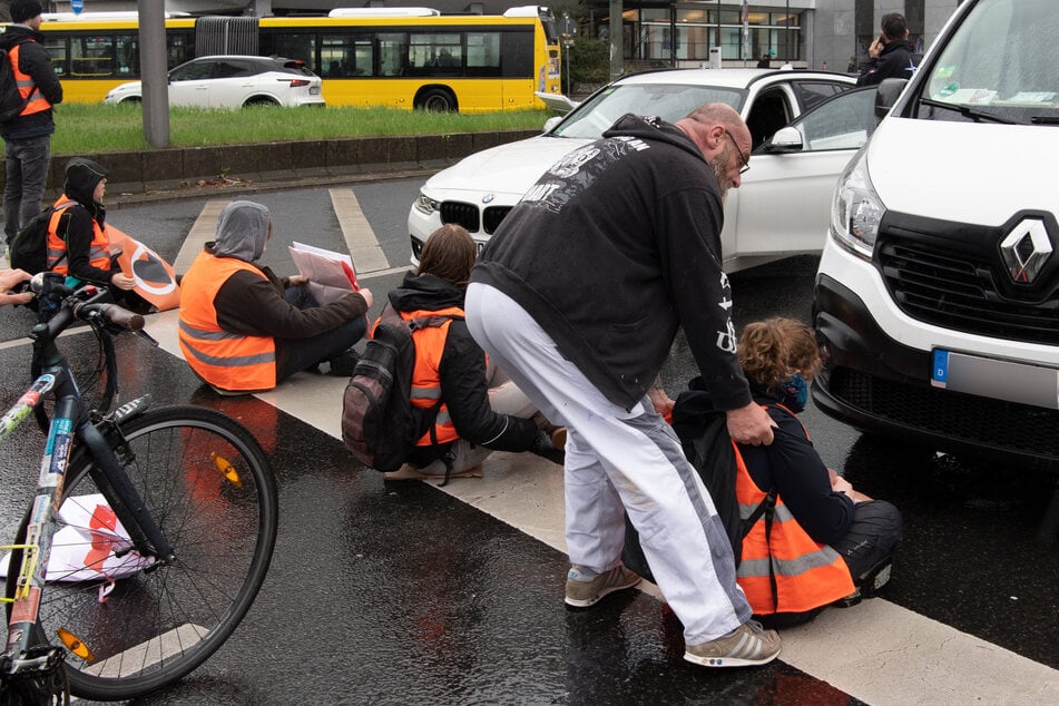 Klimaaktivisten der "Letzen Generation" blockieren eine belebte Autostraße.