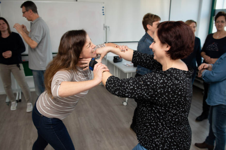 Die medizinische Fachangestellten Katja (links) und Iris üben bei einem Training, wie man sich aus einem Würgegriff befreien kann.