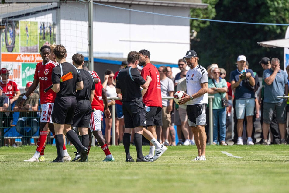 Nach dem Vorfall zeigen King Manu (22, l.) und Pele Wollitz den Schiedsrichtern klar an, dass sie das Spiel abbrechen wollen.