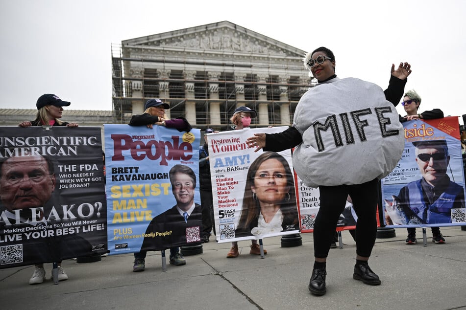 A woman dressed as a mifepristone pill dances with pro-choice activists during a rally outside the US Supreme Court on April 2, 2025.