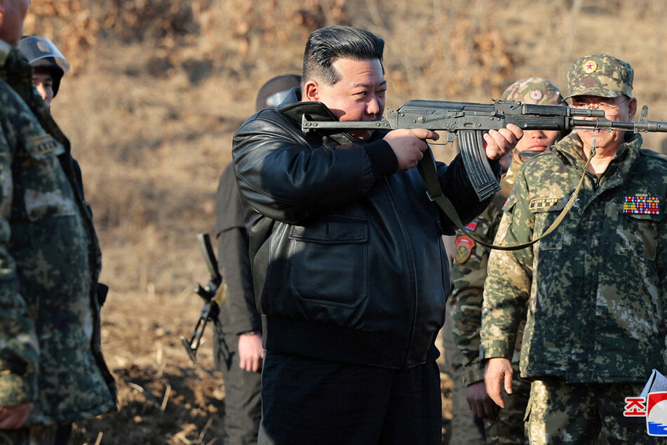 Kim Jong-un was pictured aiming a rifle during a visit to a North Korean army training base as he urged the intensification of "war drills."