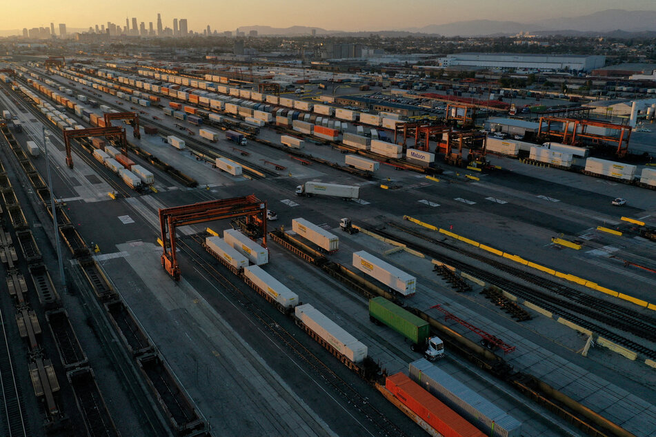 An aerial view of gantry cranes, shipping containers, and freight trains at the Union Pacific Los Angeles Intermodal Facility rail yard in Commerce, California.