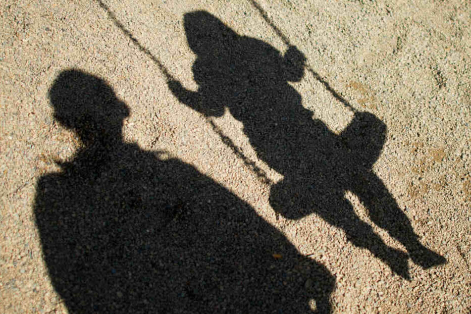 Ein Mann spricht ein Mädchen auf einem Spielplatz an. (Symbolbild)