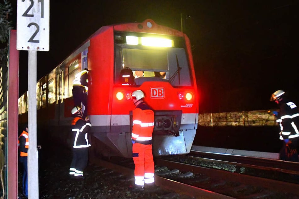 Feuerwehrleute kümmern sich nach dem Unfall um den S-Bahn-Fahrer.