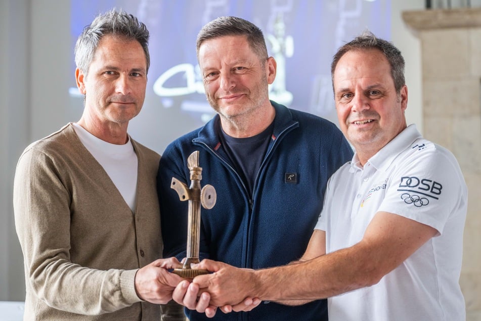 Veranstalter Sven Hertwig (exclusiv events, v.l.), Jens Köhler (Präsident Stadtsportbund Chemnitz) und Ronny Kaiser (stellvertretender Leiter Olympiastützpunkt) zeigen den Chemmy.