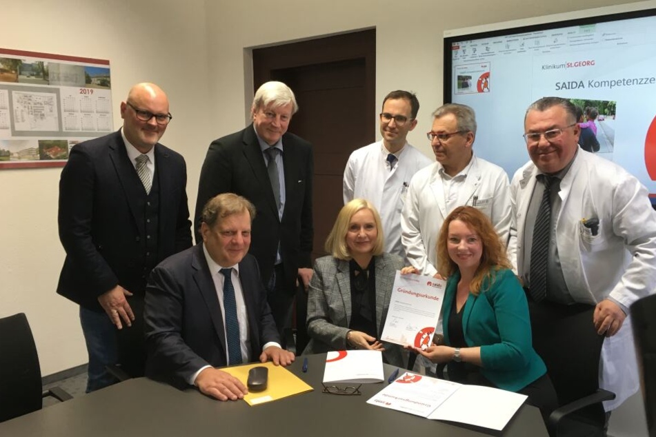 Freuen sich auf die gemeinsame Zusammenarbeit: Bürgermeister T.Fabian, Klinik-Chefin Dr. I. Minde, S. Schwarz (sitzend) sowie L. Kindermann, Dr. Ch. Geyer, Prof. T. Kremer, Prof. W. Köhler und Prof. A. Hamza (stehend).