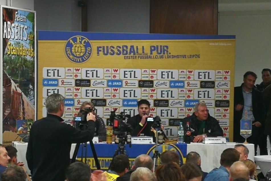 Unfreiwillige Bierdusche: BSG-Trainer Dietmar Demuth (re.) sitzt nach dem Becherwurf mit nassen Klamotten in der Pressekonferenz.