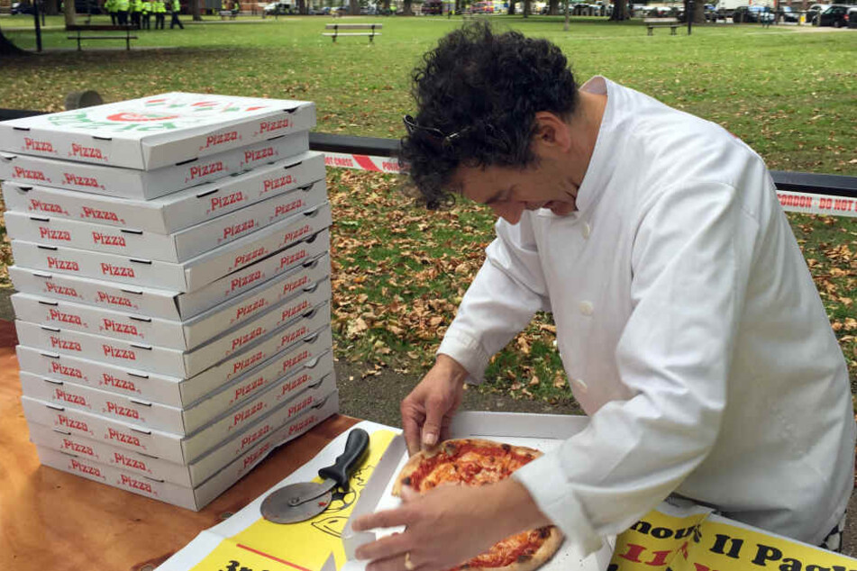 Der Pizzabäcker Teo Catino schneidet Pizza in London. Catino verschenkte Pizza und Wasser um sich bei den Rettungs- und Sicherheitskräften zu bedanken.