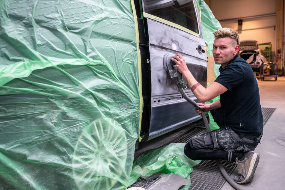 Lackierer Andy Hähle (32) schleift die Tür des Mercedes-Busses ab.