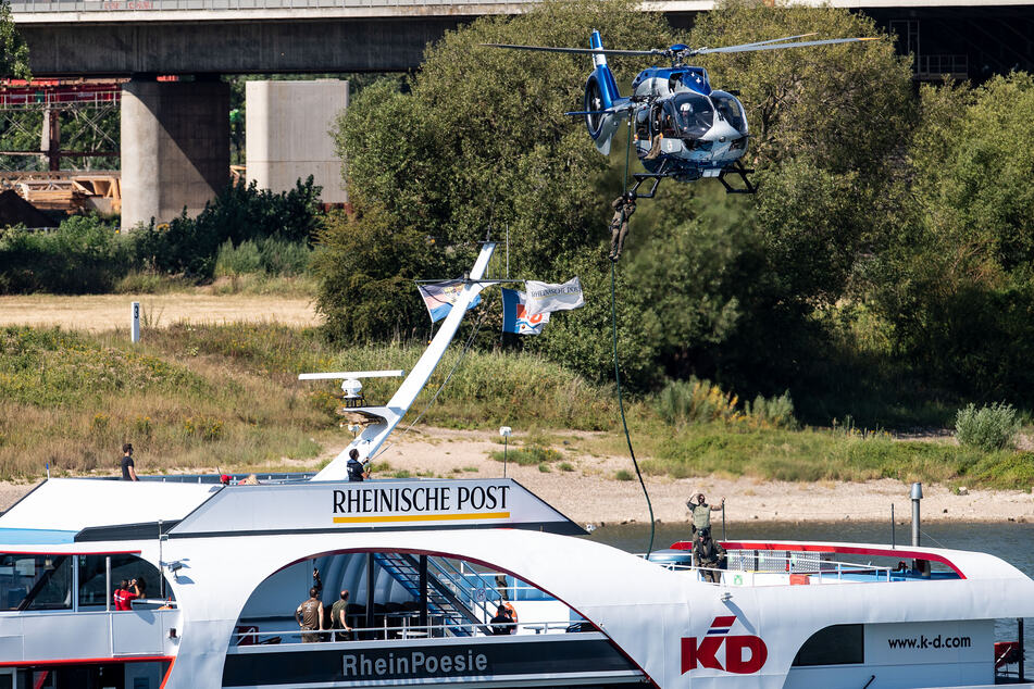 Einsatzkräfte eines Spezialeinsatzkommandos (SEK) der Polizei seilen sich während einer Übung von einem Hubschrauber auf ein Ausflugsschiff auf dem Rhein ab.