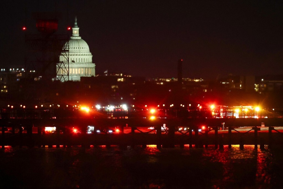 The US Capitol is visible as emergency response units assemble on the tarmac at Ronald Reagan Washington Airport as search and rescue operations are underway after a plane crashed into the Potomac River.