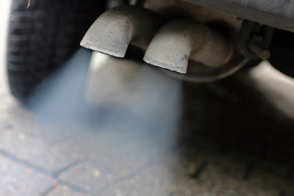 Abgase strömen aus dem Auspuff eines alten Fahrzeuges mit Dieselmotor.