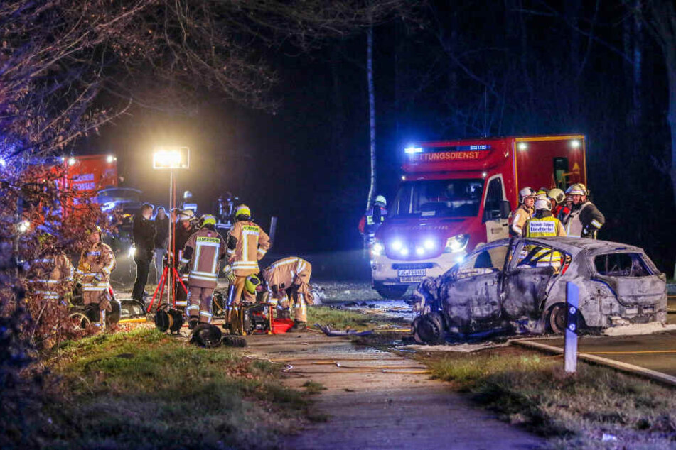 22.12.2018, Nordrhein-Westfalen, Stolberg: Feuerwehrleute stehen an zwei Fahrzeugen, die frontal zusammengestoßen waren.