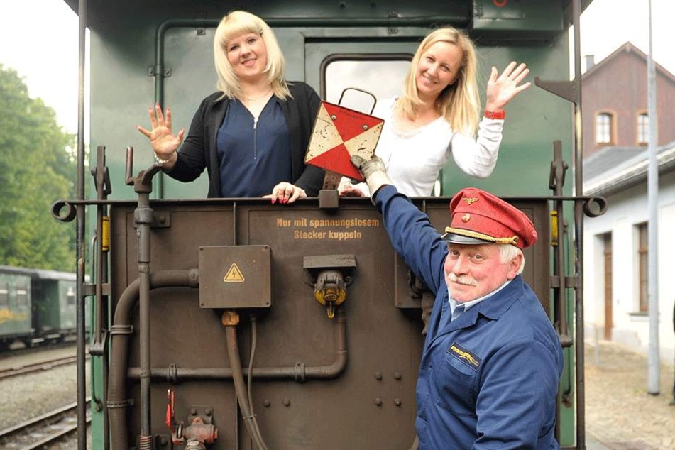 Mit der Fichtelbergbahn beim Fotoshooting um die Wette lächeln: Heidi Glaser (28), Anke Neubert (39) und Fahrdienstleiter Uwe Schulze (49, v.l.) zeigen schon mal, wie das aussehen könnte.