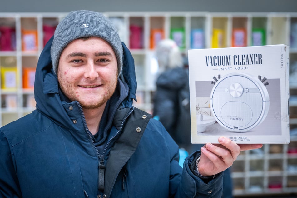 Andres Perez (24) hält stolz seinen frisch gezogenen Saugroboter.