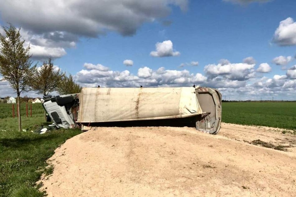 Ein mit Sand beladener Lkw ist auf einer Ortsverbindung in Brandenburg umgekippt.