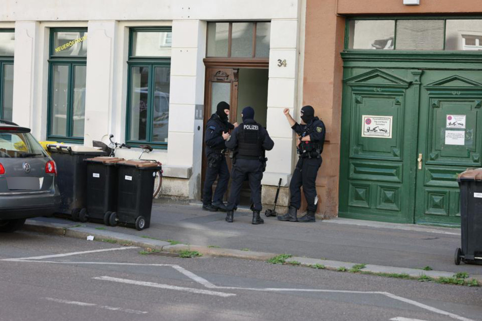 Mehrere Polizeibeamte stehen vor einer Wohnung in Leipzig-Connewitz.