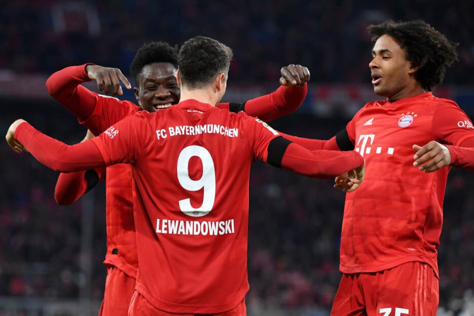 Bayerns Robert Lewandowski (M) jubelt mit Alphonso Davies (l) und Joshua Zirkee (r).