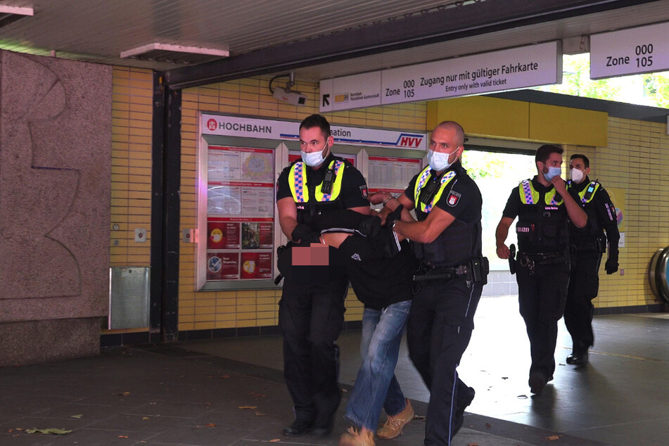Die Polizei führt den Portemonnaie-Dieb ab.