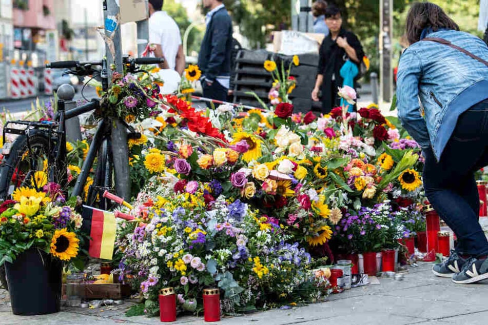 Mit Blumen und Kerzen gedenken Menschen der Opfer des Verkehrsunfalls.