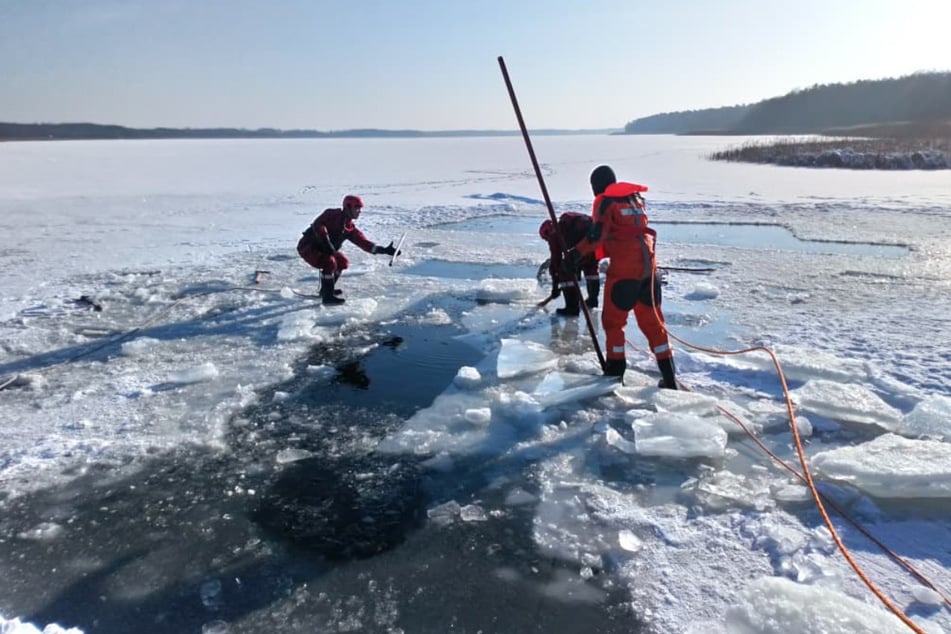 Die Kameraden der Feuerwehr schlugen weitere Löcher in das Eis auf dem See, um den Mann zu finden.