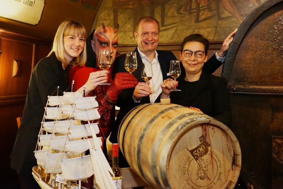 Die Jubiläumsbotschafterinnen Eleni Mercklein (l.) und Tanja Pieper, Mephisto und Wirt René Stoffregen freuen sich, das 500. Jubiläum von Auerbachs Keller zu feiern.