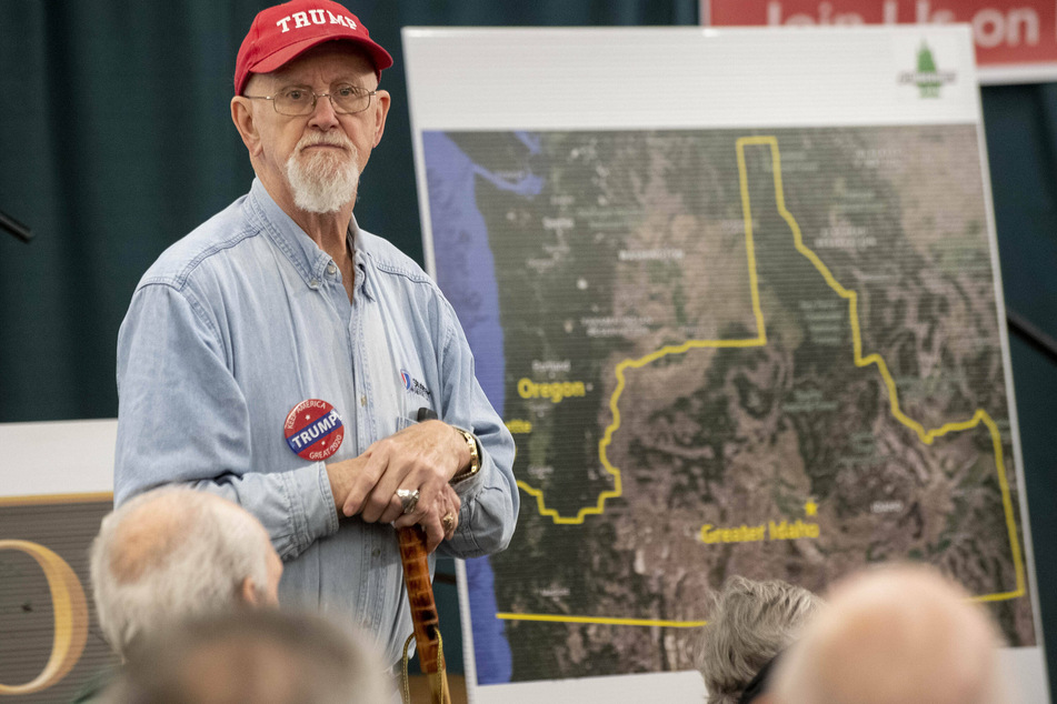 An advocate for the Oregon counties' secession stands in front of a proposed map of Idaho's new borders.