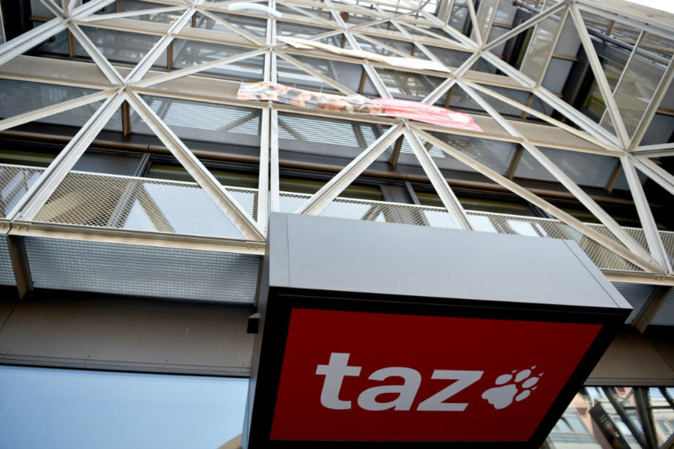 Das Logo der Tageszeitung "taz" ist am Eingang des Redaktionsgebäudes in Berlin-Mitte zu sehen.