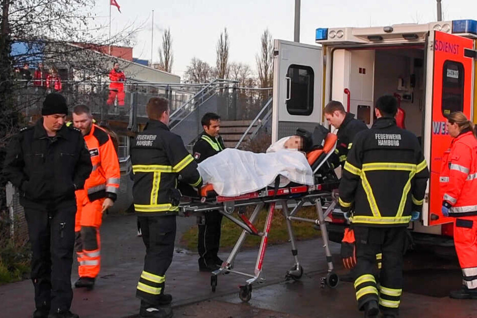 Der Verletzte wird in einen Rettungswagen geschoben und in eine Klinik gebracht.
