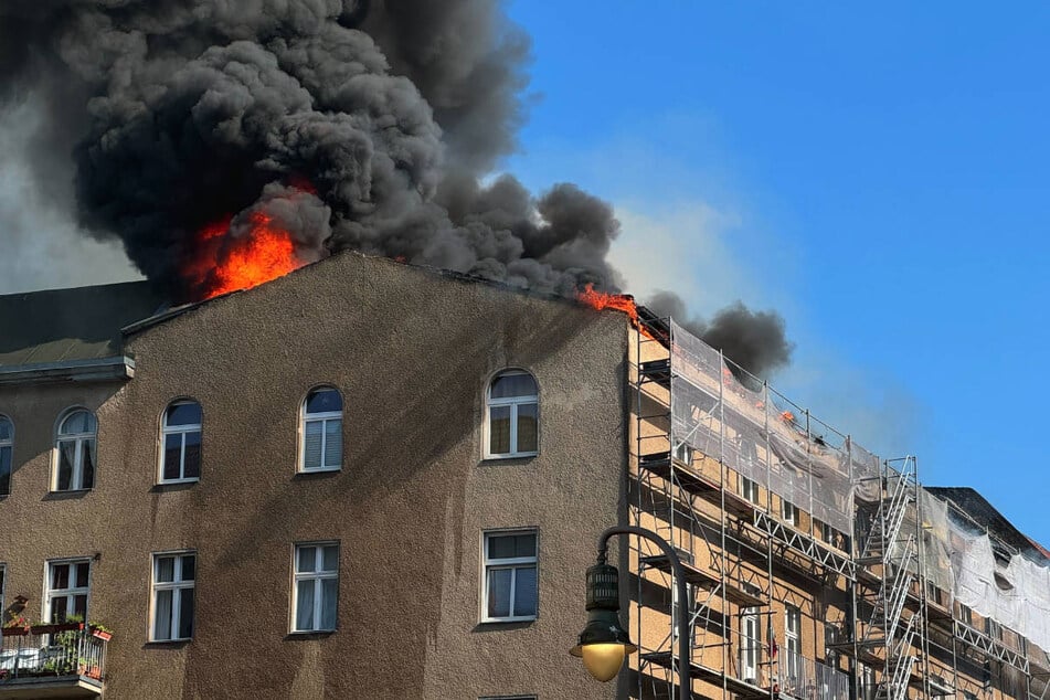 Über dem Dach des brennenden Hauses steigt eine dicke schwarze Rauchwolke auf ...