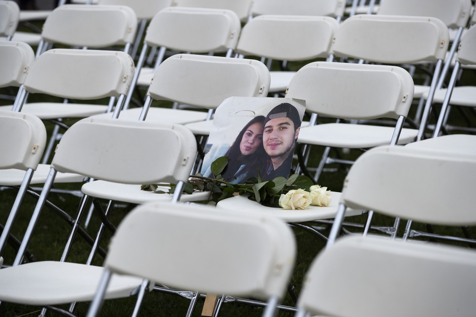 Bryce Fredriksz und seine Freundin Daisy. In einem Park gegenüber der russischen Botschaft wurden 298 leeren Stühlen platziert. Jeder steht für eines der 298 Opfer.