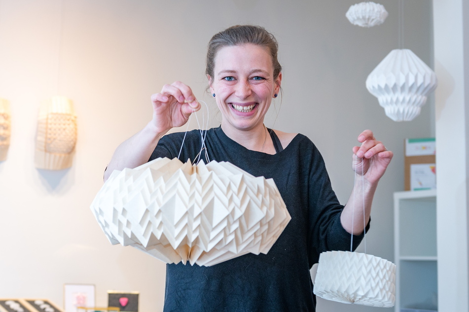 Künstlerin Maria Seidel zeigt stolz ihre Papier-Küchenlampe (links) und das NASA-Modell.