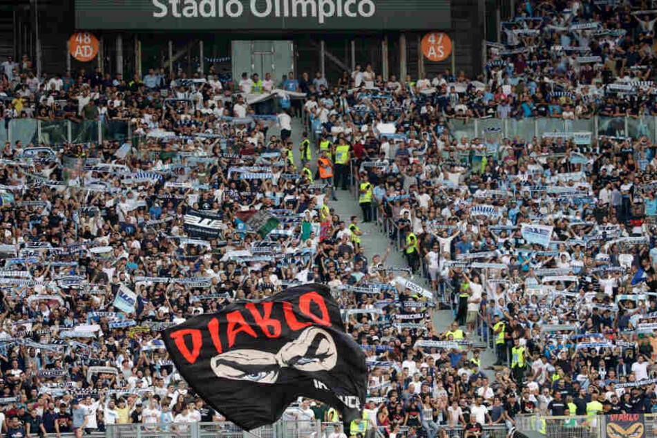 Fans von Lazio Rom halten Schals und schwenken eine Fahne vor Beginn des Spiels.