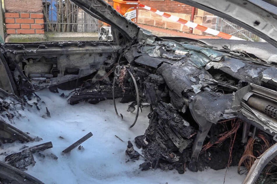 Ein ausgebranntes Fahrzeug steht auf einer Straße. Ein neunjähriger Bub hat seine zweijährige Schwester aus diesem brennenden Auto gerettet.