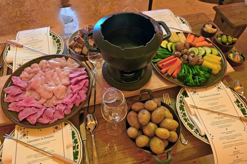 Spätestens wenn der Topf mit heißem Öl oder flüssigem Käse serviert wird, fühlt man sich in der Almhütte im Innenhof des Taschenbergpalais wie auf einer Berghütte in Österreich