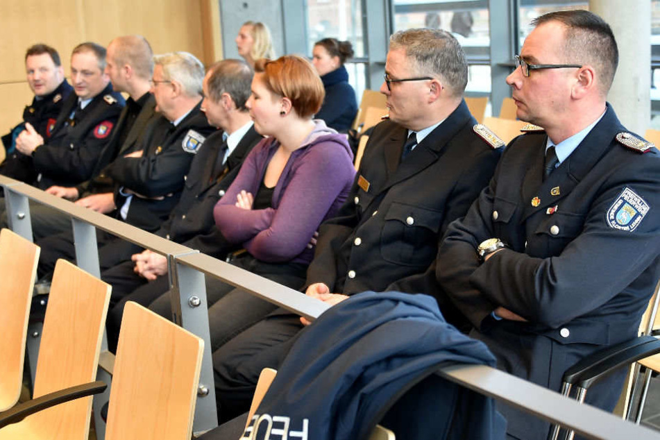 Feuerwehrleute warten im Amtsgericht auf den Prozessbeginn.