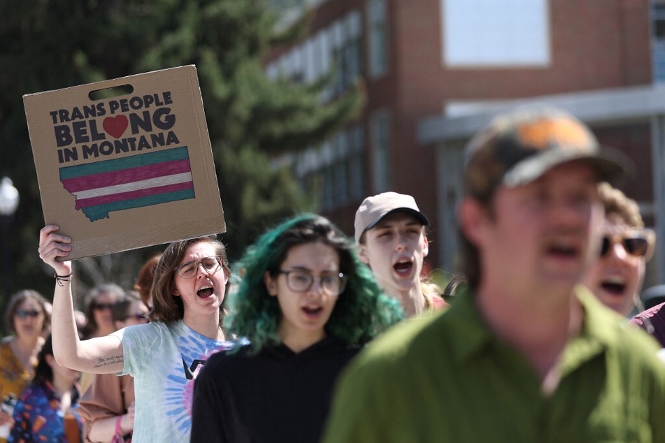 Transgender rights activists hold signs as they march through the University of Montana campus in Missoula, Montana.