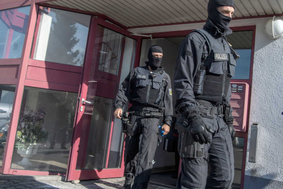 Vermummte Beamte der Bundespolizei kommen aus einem Bordell.