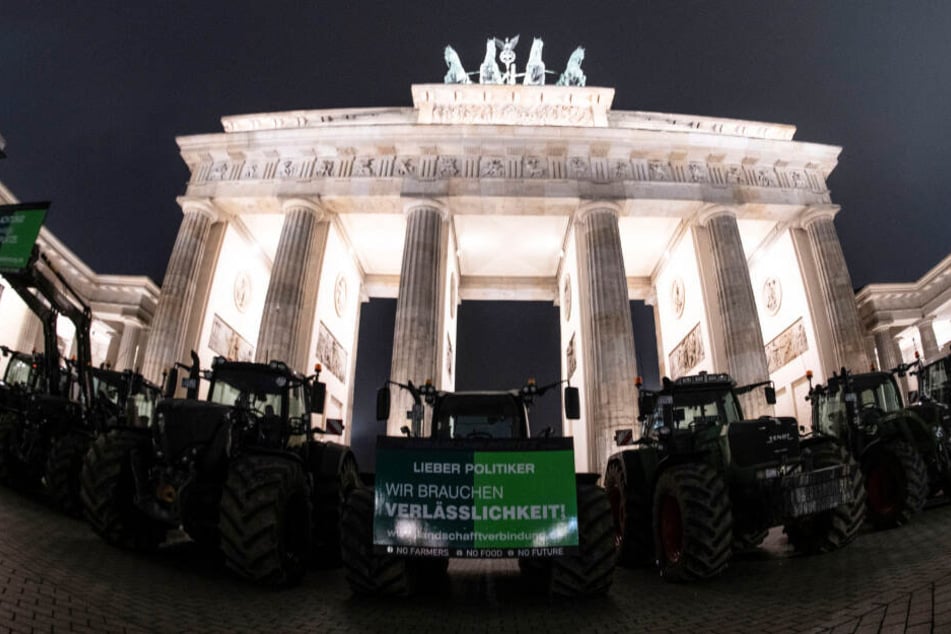 Bauern mit ihren Traktoren stehen vor dem Brandenburger Tor.