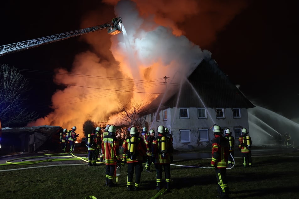 Von allen Seiten kämpfen Feuerwehrleute gegen das Feuer. Das angrenzende Wohnhaus blieb so größtenteils verschont.