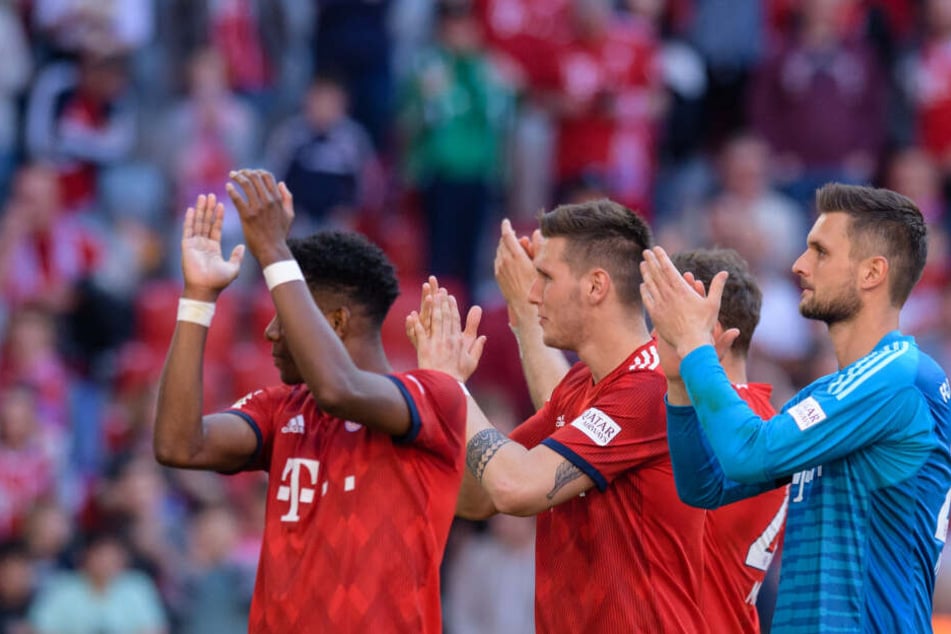 David Alaba (l-r), Niklas Süle und Sven Ulreich vom FC Bayern München feiern ihren Sieg gegen Bremen mit den Fans.